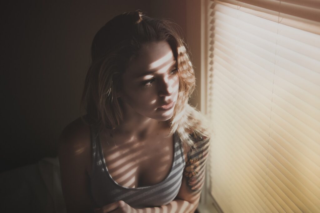 woman looking through window blinds-Stop Liking Your Crush