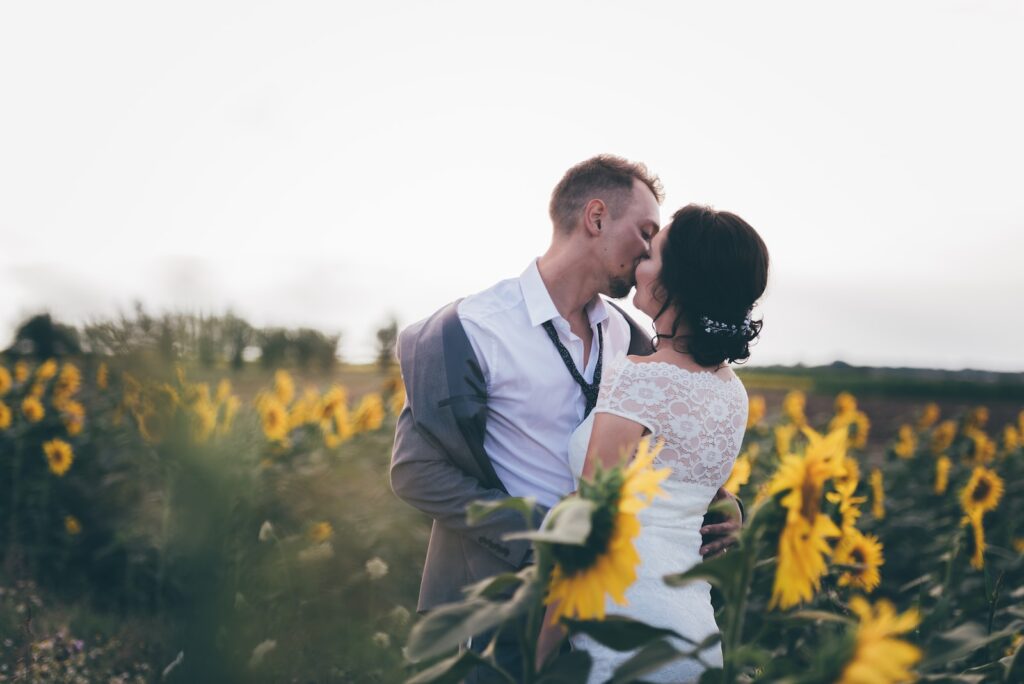 man and woman kissing in middle of sunflower field- Infidelity in a Marriage