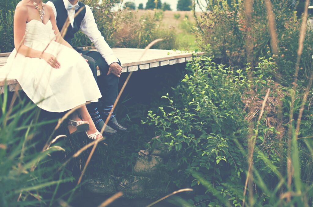 couple sitting on wooden bridge- Infidelity in a Marriage