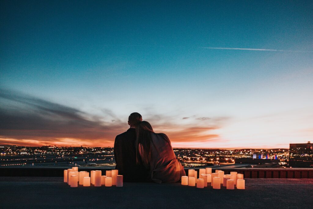 couple sitting on the field facing the city- your relationship is worth saving