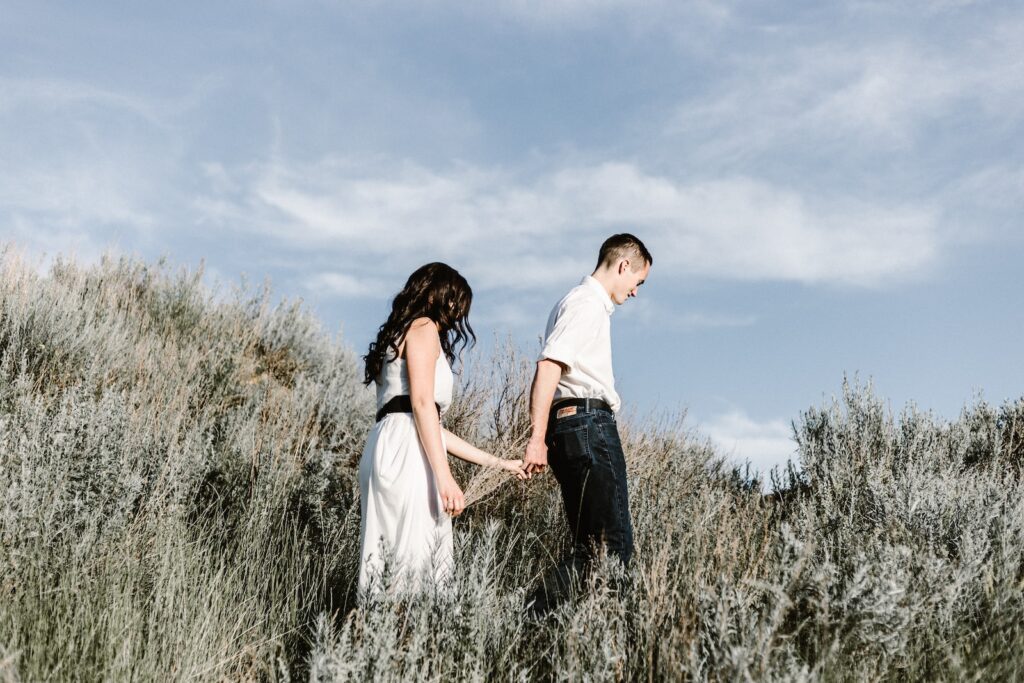 couple walks of grassy field- jealousy in a relationship