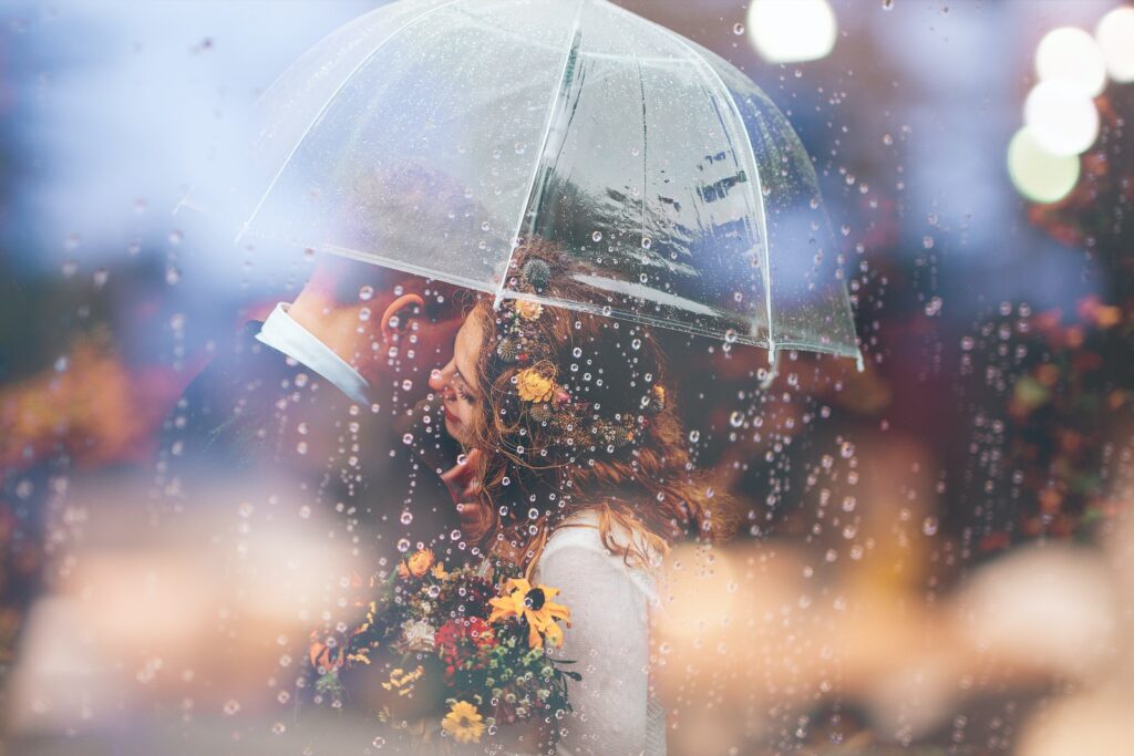 a bride and groom kiss in the rain under an umbrella- Make Him Miss You