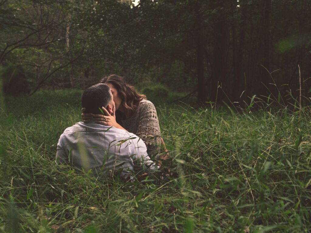 man and woman kissing on green grass field- deal with conflicts in a relationship