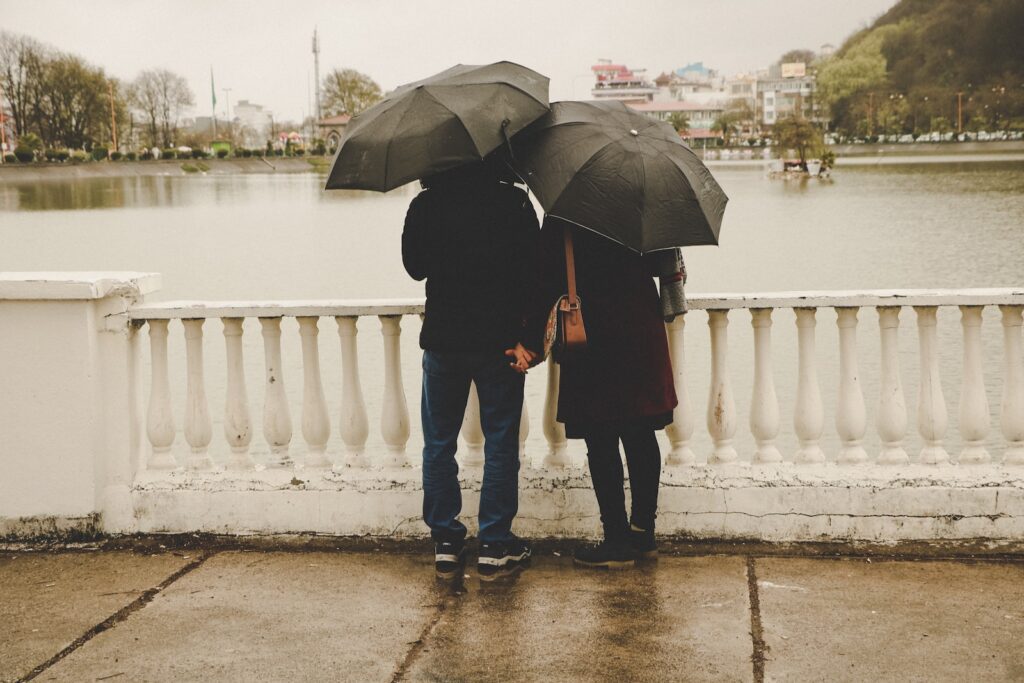 man and woman holding black umbrellas-cheating