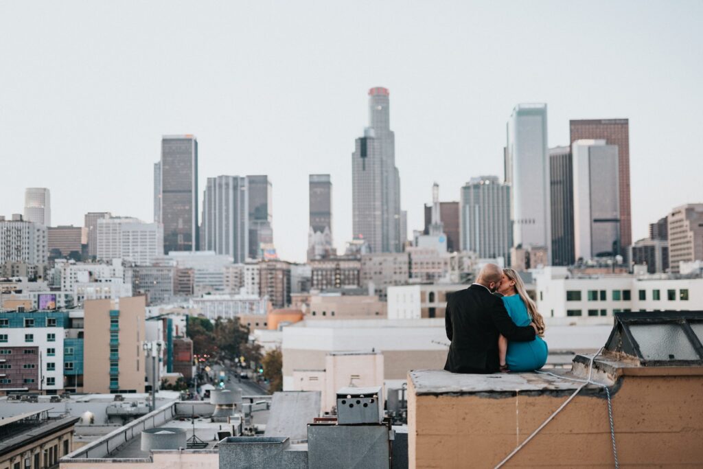 man in blue long sleeve shirt sitting on brown wooden table looking at city buildings during-lasting relationship