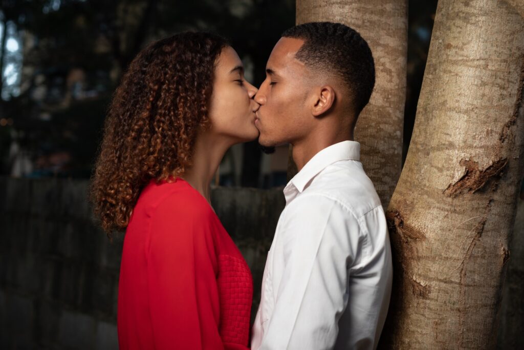 man in white dress shirt kissing woman in red dress - Bonding through shared experiences