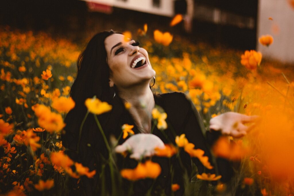 woman laughing on flower field- Rejection from Your Crush