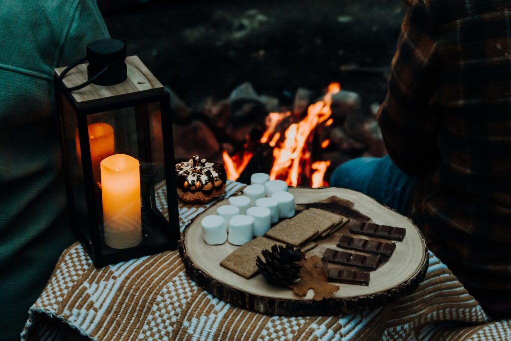 a person sitting in front of a campfire with a tray of marshmallow-a Healthy and Loving Relationship