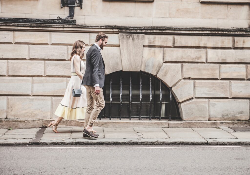 man and woman walking beside a road during daytime-Happy Couples
