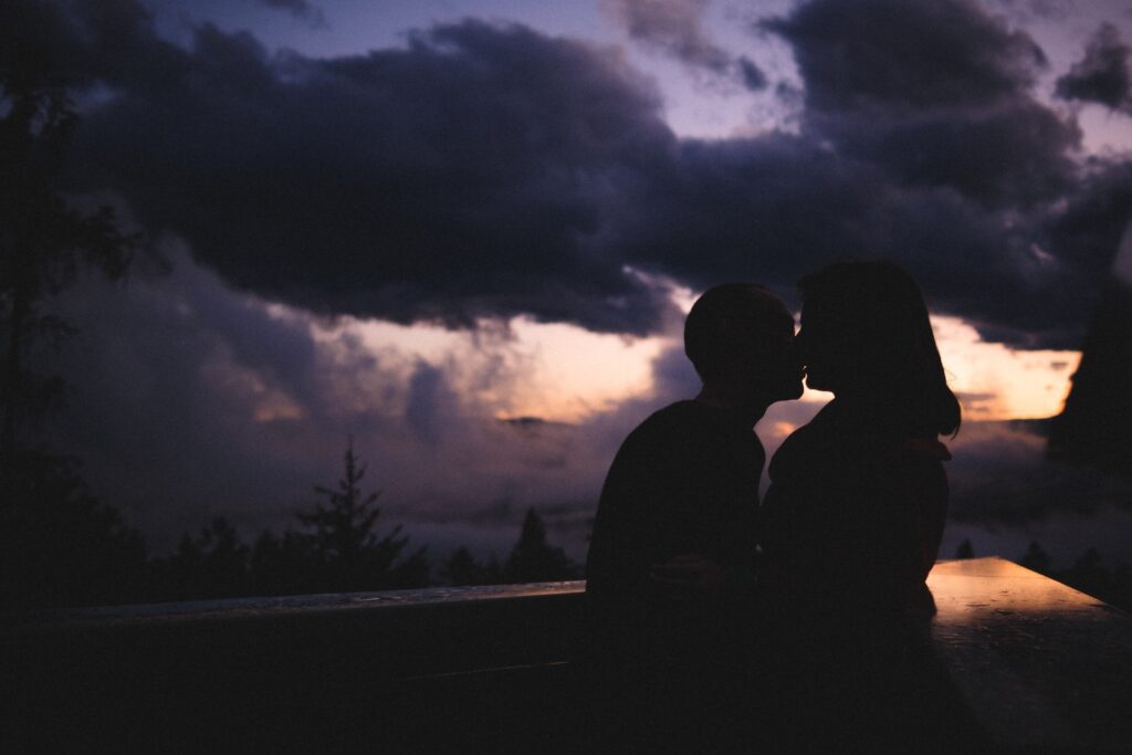 silhouette of man and woman standing on road during night time-kiss a boy for the first time