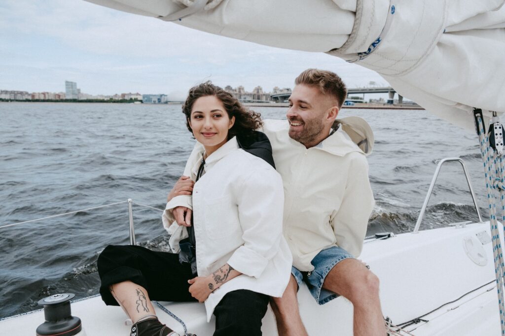 Man in White Suit Jacket Sitting Beside Woman in Blue Denim Shorts on Boat Celebrate Your Partner's Achievements