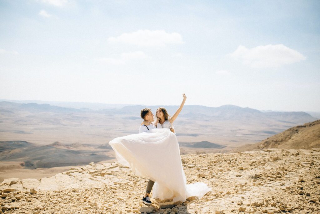 Groom Carrying Bride in the Desert Ready for a Joint Financial Plan