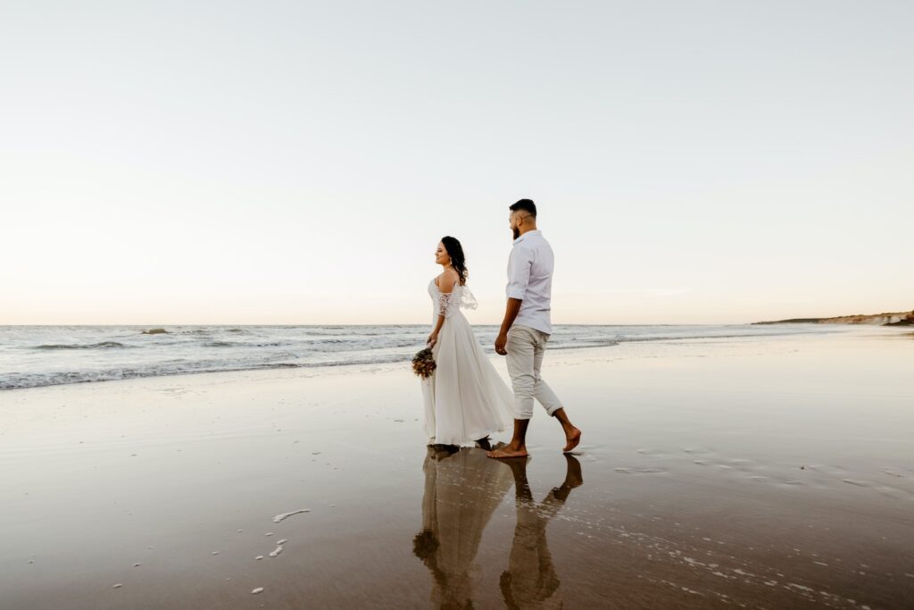 Romantic newlyweds walking on sandy beach at sundown Committed Relationship