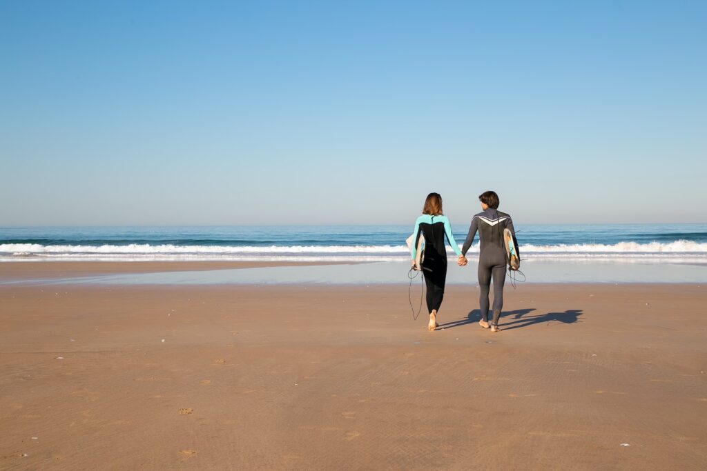 Couple in Full Body Swimwear Walking on Shore Seduction Bible
