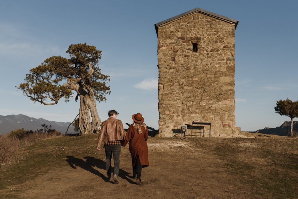 Faceless stylish couple walking towards ancient tower in picturesque nature Obsession Formula