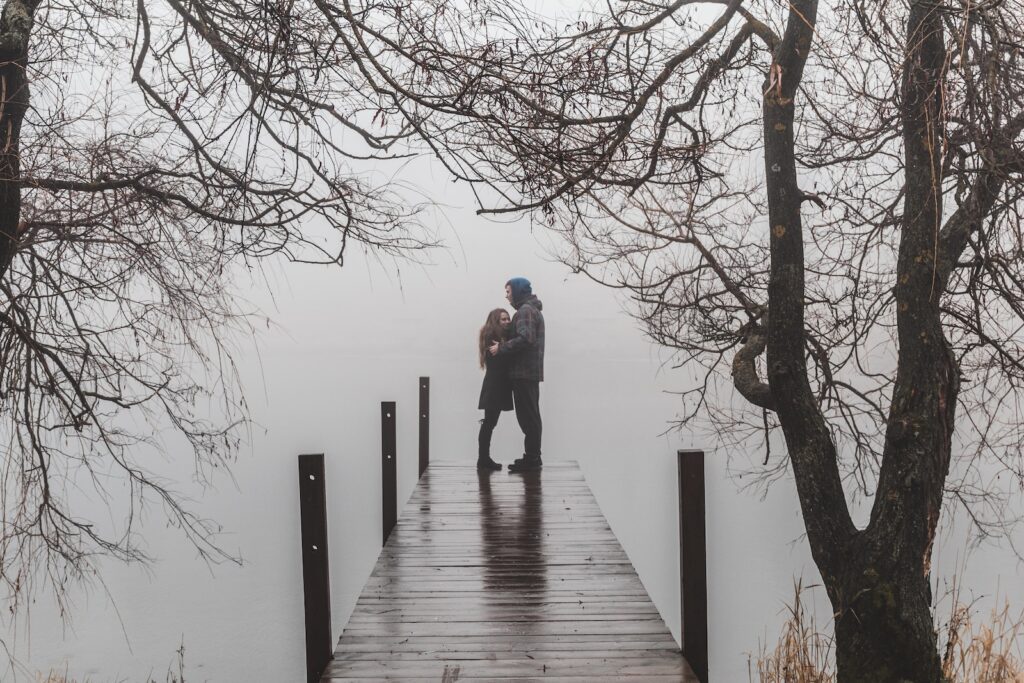 man and woman facing each other and standing on beach dock surrounded with bare trees under foggy season-Toxic Friendship