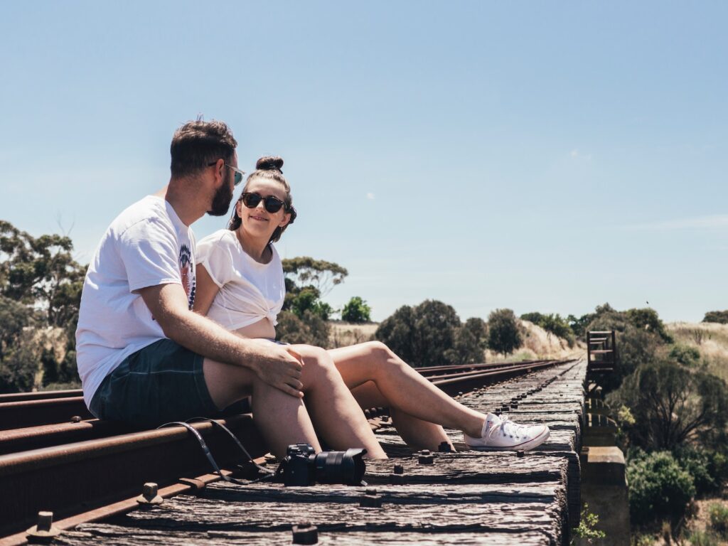 man and woman sitting on train rail-Romantic Surprises