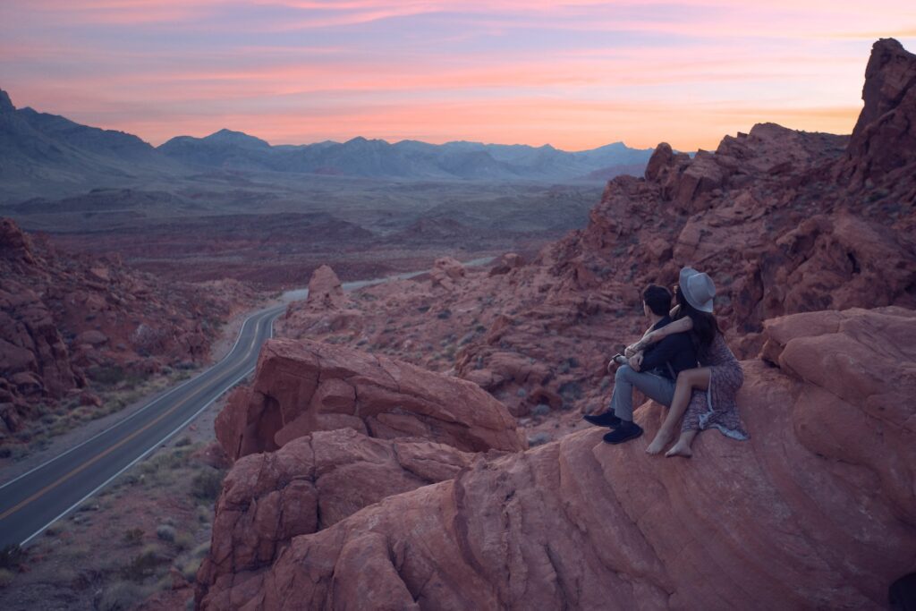 two people sitting on top of a large rock-Fun Date Ideas