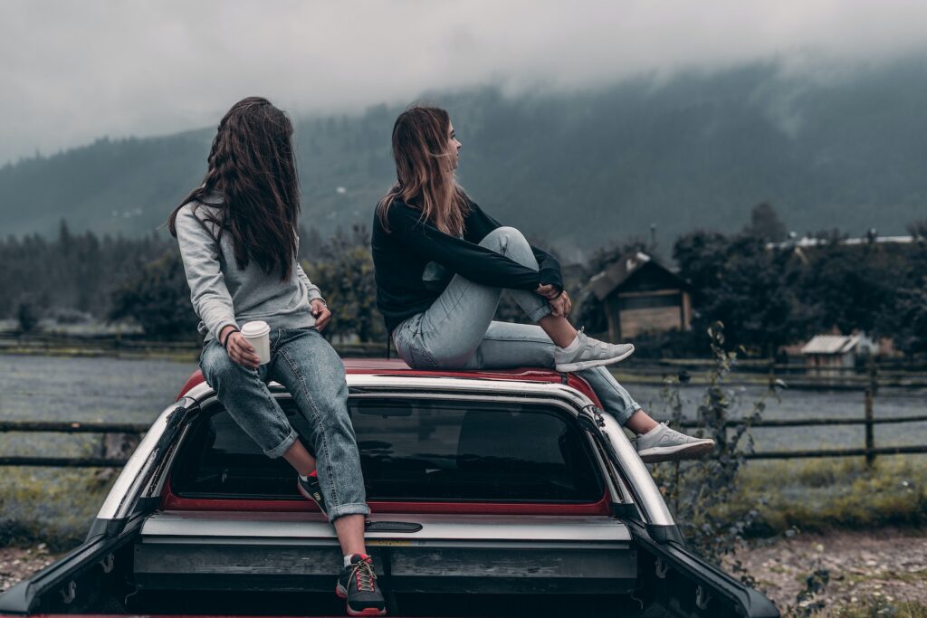 Two Women Sitting on Vehicle Roofs-Balancing Work and Marriage