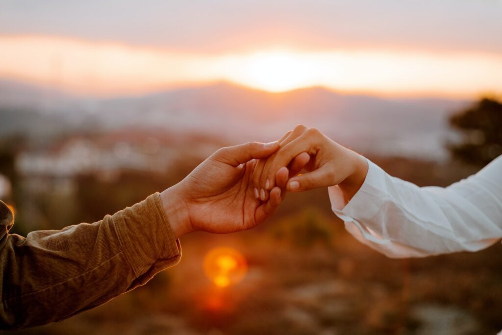 Unrecognizable couple holding hands at sunset-Your Partner Admires You