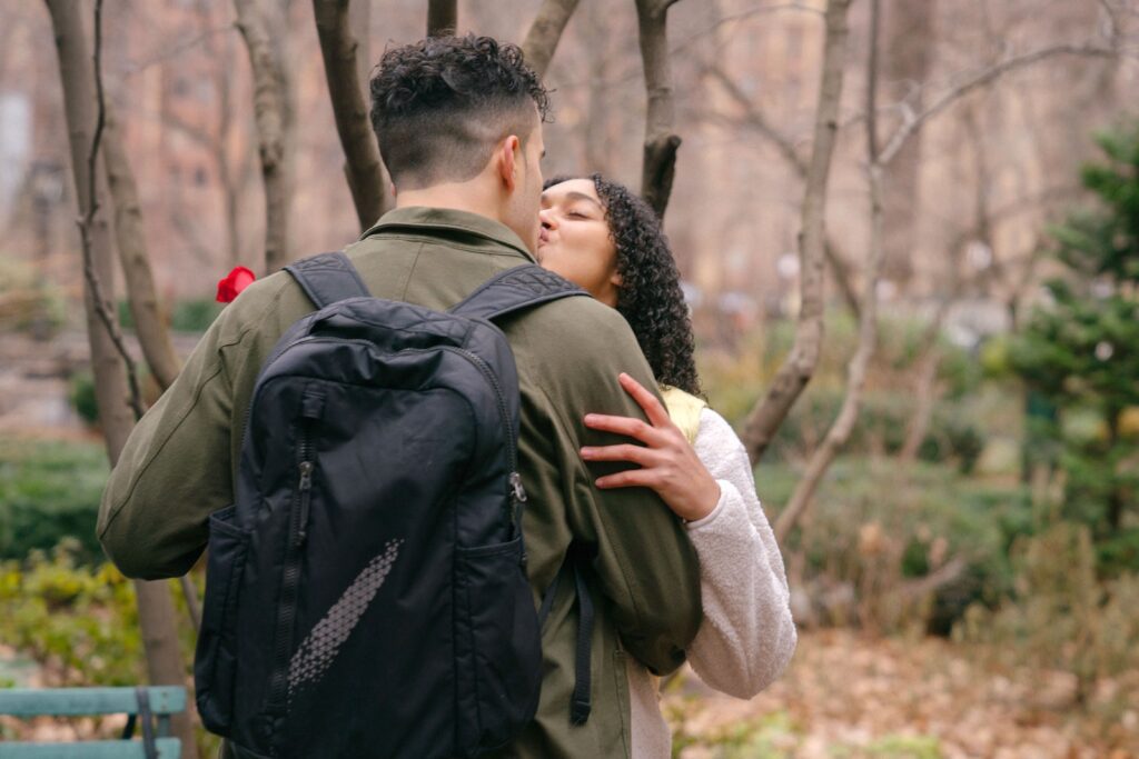 Anonymous ethnic couple kissing in park near trees and plants-Healthy Jealousy