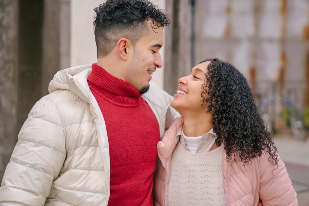 Positive Hispanic couple hugging while walking on street-Falling for You