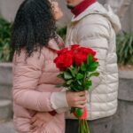 Side view of crop couple wearing warm clothes standing close with bunch of tied roses and embracing-Bible Say About Supporting Your Spouse