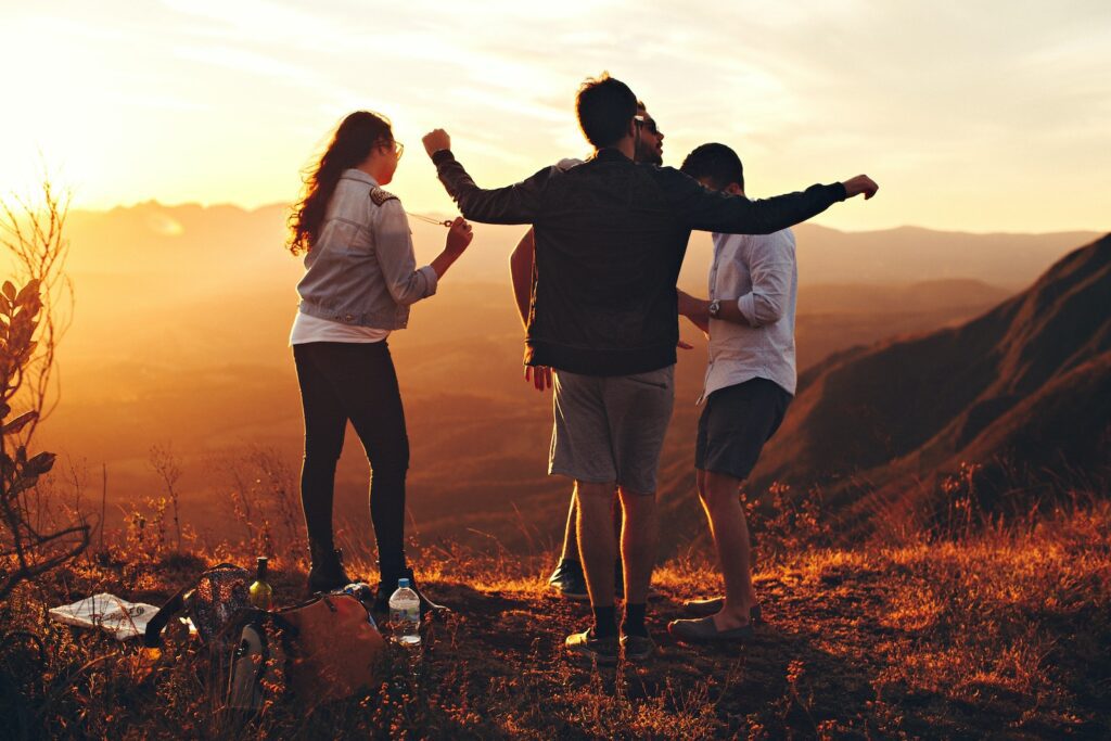 Four Person Standing at Top of Grassy Mountain-Communicate Effectively on a First Date