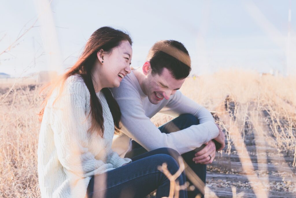 photo of man and woman laughing during daytime-dating profile tips for women