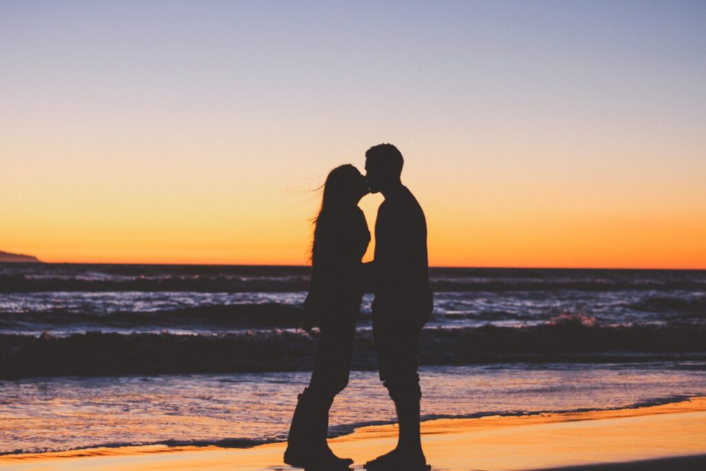silhouette of couple sitting on seashore-Good Morning Messages for Him That Touch the Heart